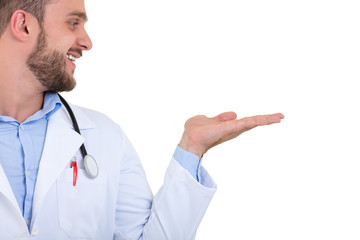 Portrait of a smiling male doctor pointing finger away isolated on a white background