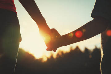 Wall Mural - silhouette of parent and child holding hands at sunset