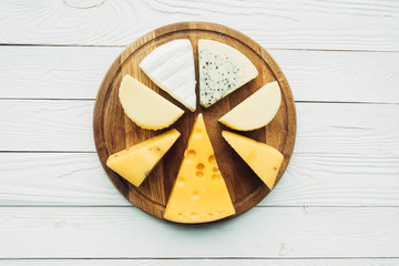 Wall Mural - assorted types of cheese on cutting board