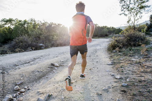 Plakat sport człowiek z zgrywanie lekkoatletycznego i mięśni nóg pod górę z drogi w treningu joggingu treningu