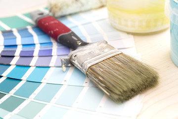 Color palette guide and painting supplies, paint brushes and color cans on wooden background