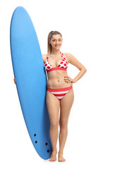 Poster - Young woman in bikini holding a surfboard