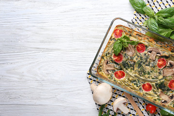 Canvas Print - Spinach frittata in baking dish and vegetables on table