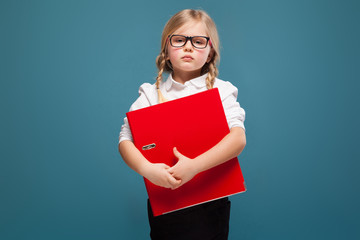 Wall Mural - Pretty, cute little girl in white shirt, glasses and black trousers hold red paper folder