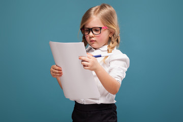 Wall Mural - Pretty, cute little girl in white shirt, glasses and black trousers hold papers