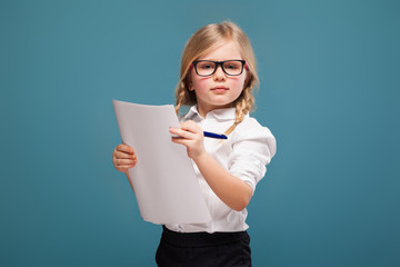 Wall Mural - Pretty, cute little girl in white shirt, glasses and black trousers hold papers