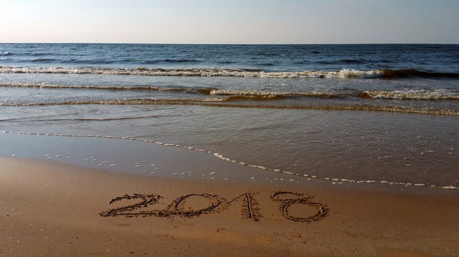 Drawing 2018 digits on the sand. Numbers drawn in the beach