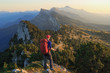 A hiker looking over the mountains during the last light of the day. Vercors, France.