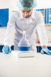 © LIGHTFIELD STUDIOS - pharmacy worker weighing flask