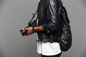 Poster - Cropped photo of stylish african man with backpack holding photo camera