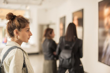 Group Of Woman Looking At Modern Painting In Art Gallery
