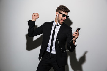 Poster - Portrait of a cheerful man in suit and tie dancing