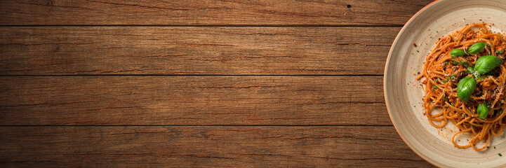 Italian pasta with tomato sauce on wooden background