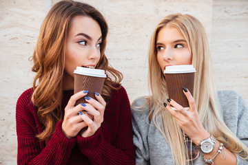 Poster - Portrait of a two pretty smiling girls holding coffee cups