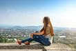 © dizfoto1973 - The girl sits on the edge of the fortress and looks at the city from a height.