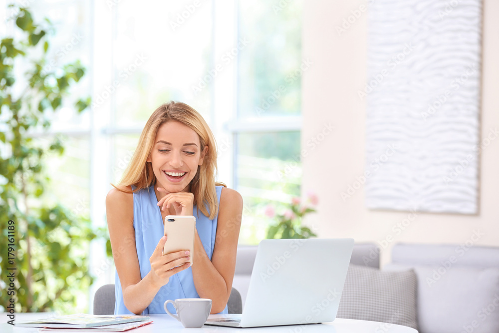 Beautiful young woman with mobile phone at home