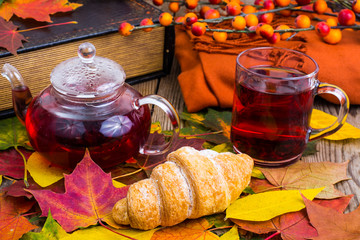 Canvas Print - Aromatic red tea, book, colorful autumn leaves on wooden table