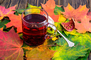 Canvas Print - Red tea with karkade, autumn leaves on wooden table