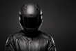 © Robert Zaleski/Stocksy - Man wearing a black leather motorcycle jacket and helmet on dark background.