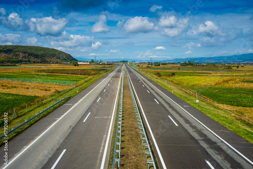 Plakat Nowożytna pusta autostrada iść przez poly