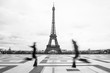 Two people run to embrace with the Eiffel Tower in the background