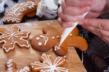Christmas Bakery. Decorating Homemade Gingerbread Man With Icing, Close Up. Festive Culinary And New Year Traditions Concept