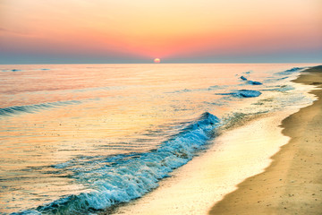  Sunset on the beach with long coastline, sun and dramatic sky 