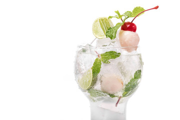 Lychee cocktail with mint leaves, lime and cherry decoration in white background