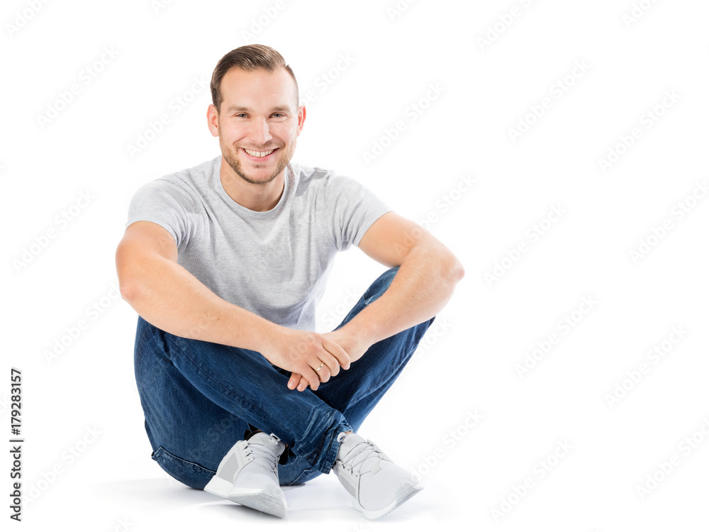 Man sitting with his legs crossed. Smiling guy. Stock Photo | Adobe Stock