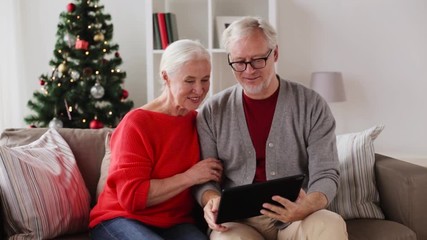 Poster - happy senior couple with tablet pc at christmas