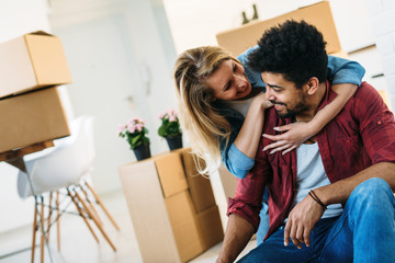 Wall Mural - home, people, moving and real estate concept - happy couple having fun while moving in