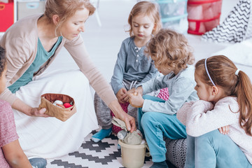 Wall Mural - Teacher giving toys children