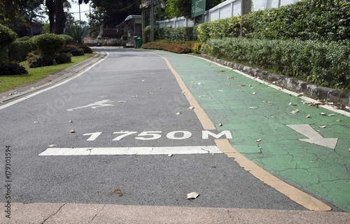 Fotografía The green bike lane and white arrow painting parallel with jogging lane and white jogging man painting