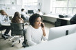 © John Fedele/Blend Images - Businesswoman talking on cell phone in office
