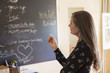 © Marc Romanelli/Blend Images - Pensive teacher holding chalk near blackboard
