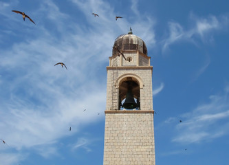 Bell Tower with Swallows against Blue Sky