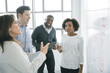 © John Fedele/Blend Images - Business people talking near whiteboard in meeting