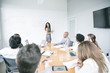© John Fedele/Blend Images - Businesswoman talking at whiteboard in meeting