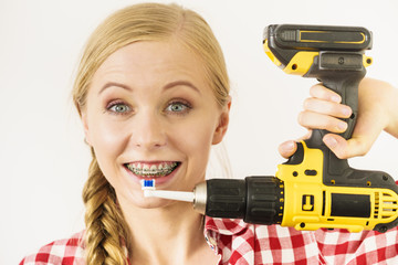 Wall Mural - Woman with braces brushing teeth with drill