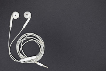 Top view of White Earphones on Black background. Copy space. Music is my life concept