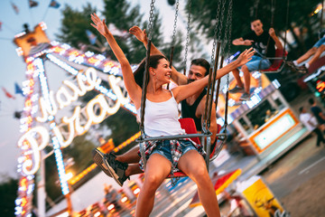 Young couple enjoying on the swings