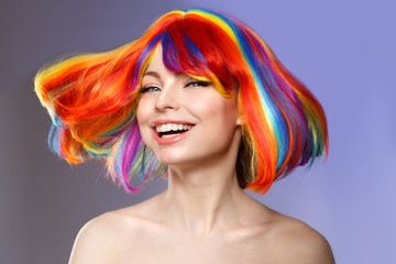 woman hair as color splash. rainbow up do short haircut. beautiful young girl model with glowing hea