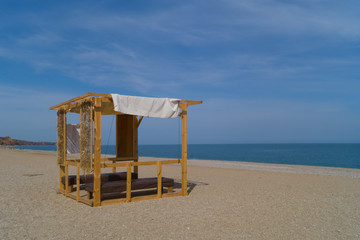 Wooden massage parlor with two tables on the beach