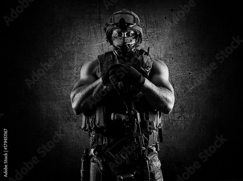 Foto  The soldier of the special unit stands with an automatic weapon at the advantage