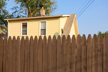 Urban House Behind A Tall Wooden Fence