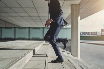 Running up businessman weairng stylish blue suit