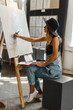 © proimagecontent - Female artist wears black hat draw picture indoor the studio