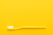 close-up plastic toothbrush on the yellow background with copy space