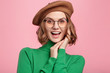 Gratified pleasant looking woman in beret and spectacles, rejoices hearing good news, glad to be promoted. Female recieves proposal from boyfriend, being overjoyed, smiles happily. Happiness concept