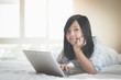 © lalalululala - Asian boy lying in bed and using laptop